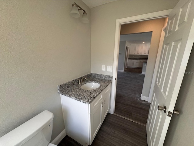 bathroom with vanity, hardwood / wood-style floors, and toilet