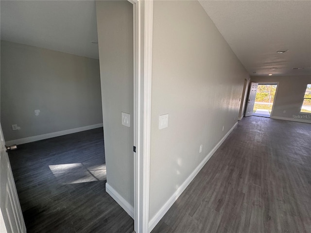 corridor with dark hardwood / wood-style flooring