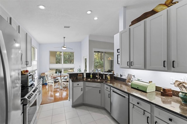 kitchen featuring gray cabinetry, ceiling fan, sink, and stainless steel appliances