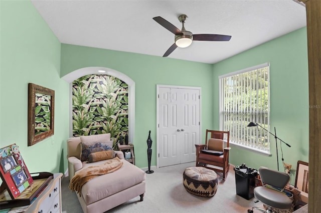 sitting room with ceiling fan and carpet floors