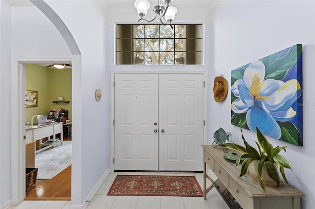 entryway with a chandelier, light hardwood / wood-style floors, and ornamental molding