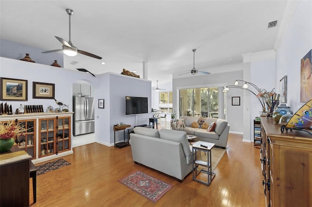 living room with hardwood / wood-style flooring, ceiling fan, and crown molding