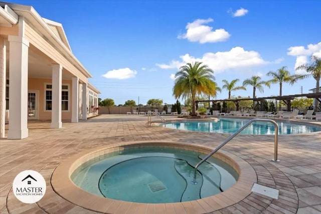 view of pool with an in ground hot tub and a patio