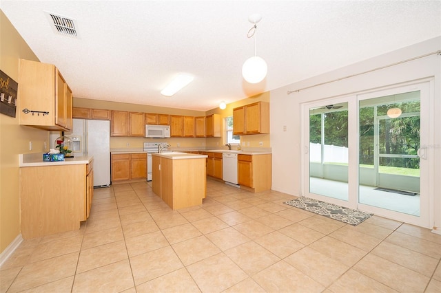 kitchen with white appliances, light tile patterned floors, a textured ceiling, decorative light fixtures, and a kitchen island