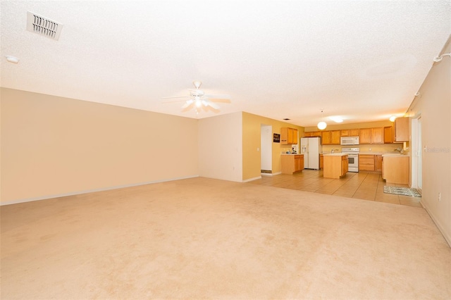 unfurnished living room with ceiling fan and light colored carpet