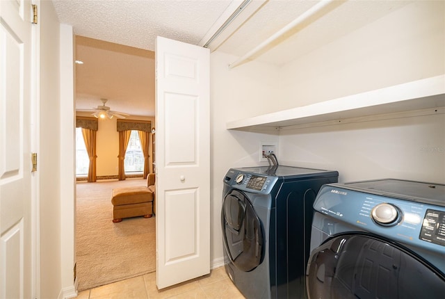 laundry room featuring ceiling fan, light colored carpet, independent washer and dryer, and a textured ceiling