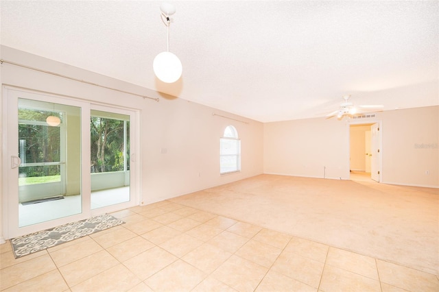 carpeted empty room with ceiling fan and a textured ceiling