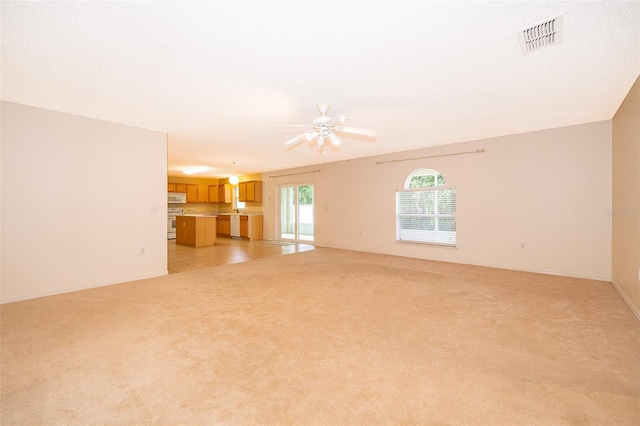 unfurnished living room with ceiling fan and light carpet