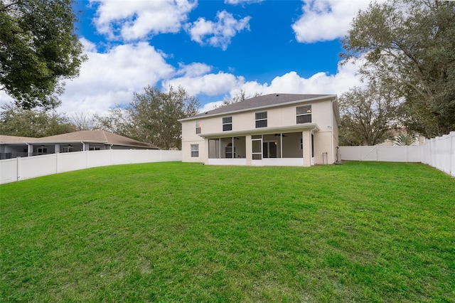 back of property featuring a sunroom and a yard