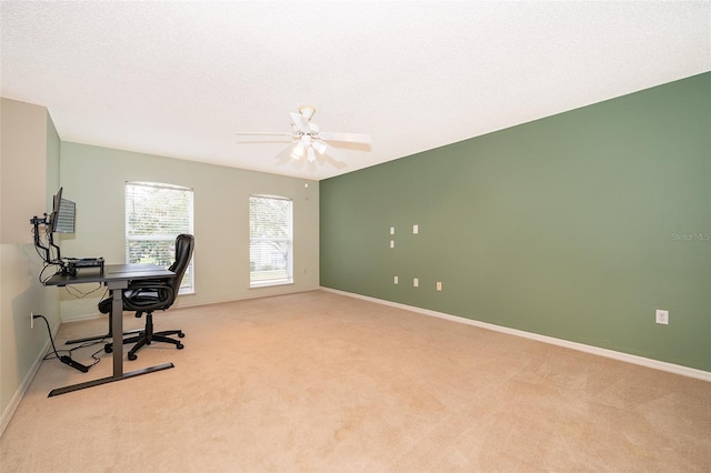 carpeted home office with ceiling fan and a textured ceiling