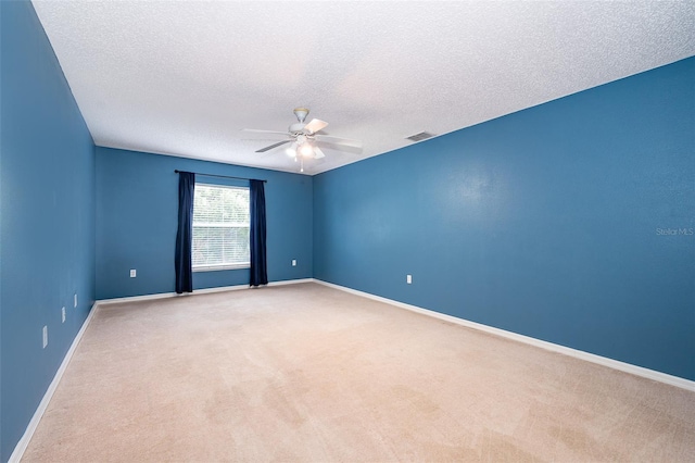 carpeted spare room with ceiling fan and a textured ceiling