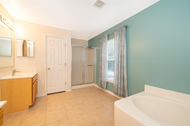 bathroom featuring tile patterned floors, vanity, and shower with separate bathtub