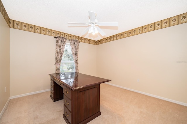 carpeted home office featuring ceiling fan