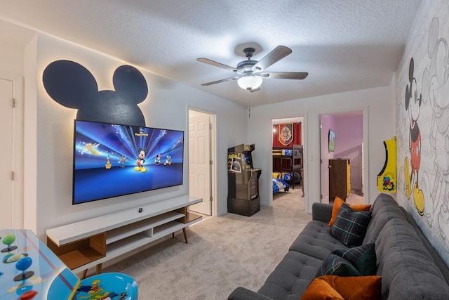 cinema with ceiling fan, light colored carpet, and a textured ceiling