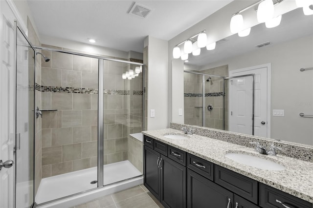 bathroom with tile patterned flooring, vanity, and an enclosed shower