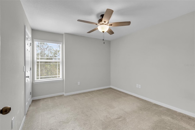 carpeted spare room featuring ceiling fan