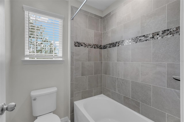 bathroom featuring toilet and tiled shower / bath