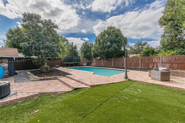 view of swimming pool with a yard, a patio, and a trampoline