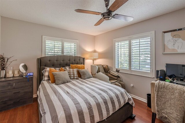 bedroom featuring ceiling fan, dark hardwood / wood-style flooring, and a textured ceiling