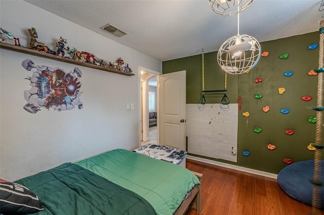 bedroom with hardwood / wood-style flooring and a textured ceiling