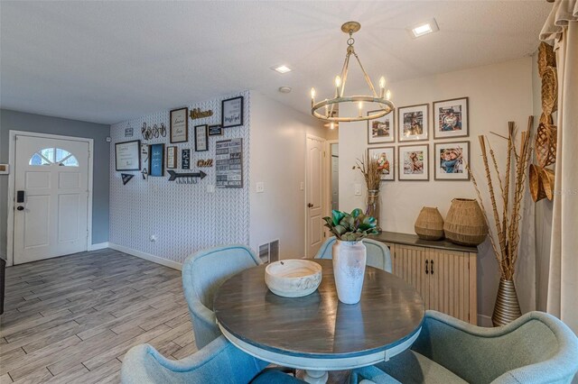 dining room with light hardwood / wood-style flooring and a chandelier