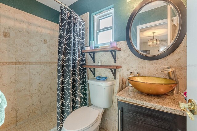 bathroom featuring a shower with shower curtain, vanity, toilet, and tile walls