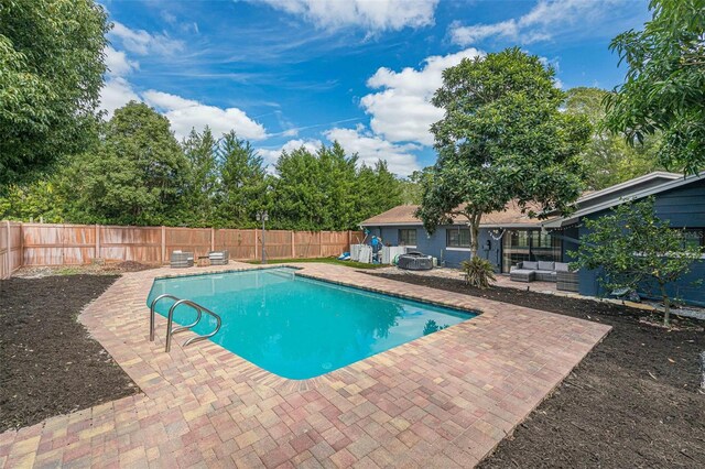 view of pool with an outdoor living space and a patio area