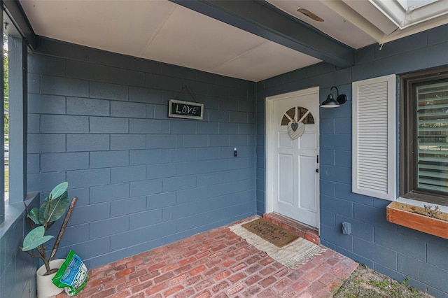 doorway to property featuring concrete block siding