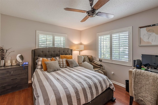 bedroom featuring ceiling fan, a textured ceiling, baseboards, and wood finished floors