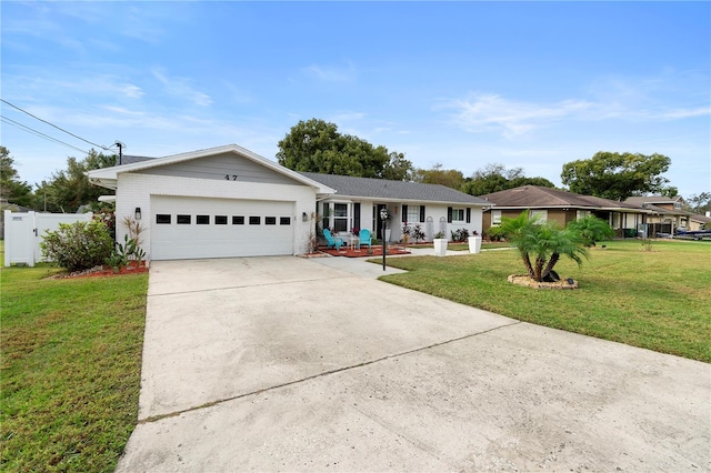 ranch-style home featuring an attached garage, driveway, a front lawn, and fence