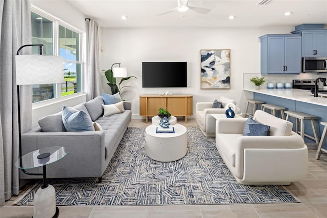 living room with ceiling fan and tile patterned flooring