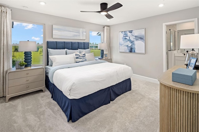 carpeted bedroom featuring multiple windows, ceiling fan, and ensuite bathroom