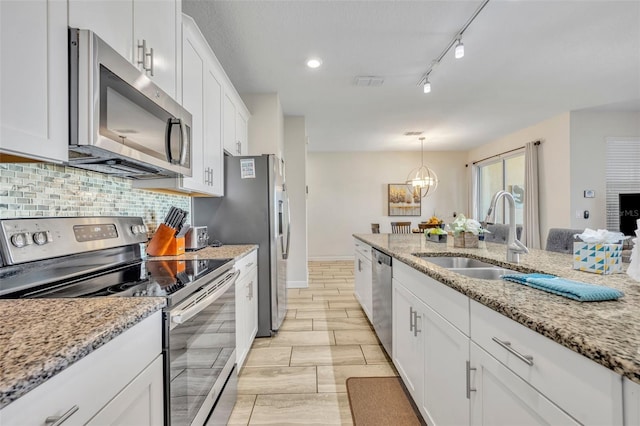 kitchen featuring a notable chandelier, sink, white cabinetry, and stainless steel appliances