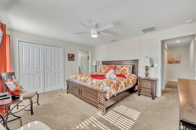 carpeted bedroom featuring ceiling fan, a textured ceiling, and a closet