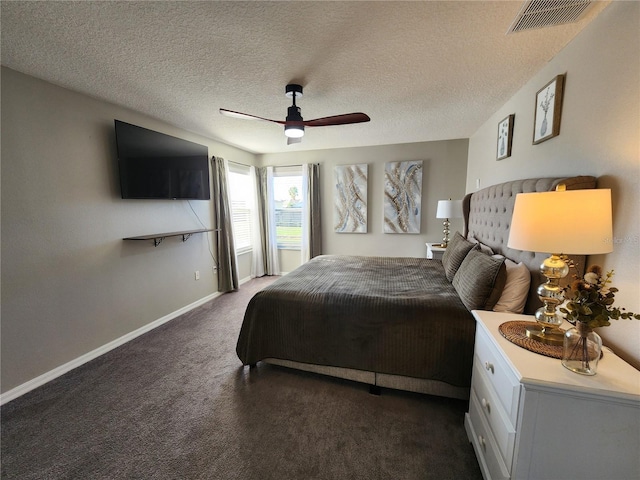 bedroom with a textured ceiling, dark carpet, and ceiling fan