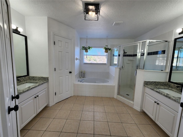 bathroom with tile patterned floors, vanity, a textured ceiling, and independent shower and bath