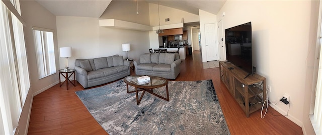 living room with dark hardwood / wood-style flooring and high vaulted ceiling