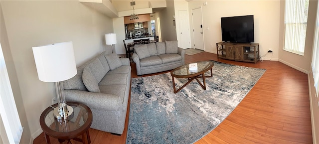 living room featuring a chandelier and wood-type flooring