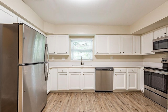 kitchen featuring white cabinetry, sink, stainless steel appliances, and light hardwood / wood-style flooring