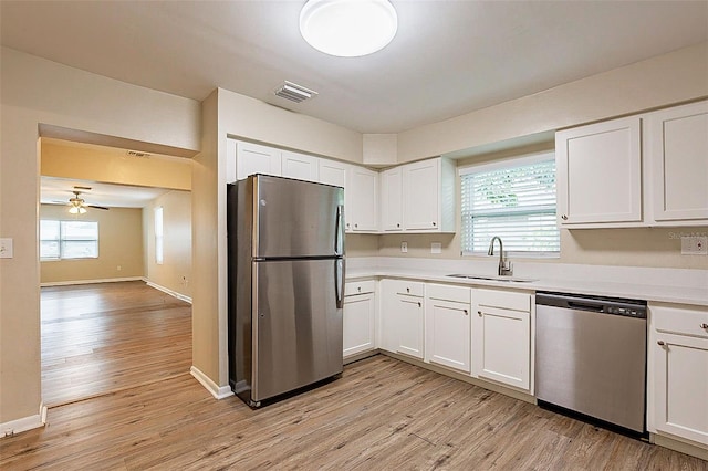 kitchen with white cabinets, stainless steel appliances, plenty of natural light, and sink