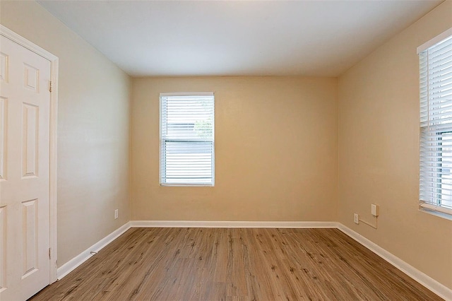 empty room with light hardwood / wood-style floors and a wealth of natural light