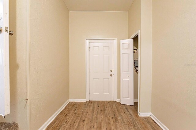 hallway with light hardwood / wood-style floors