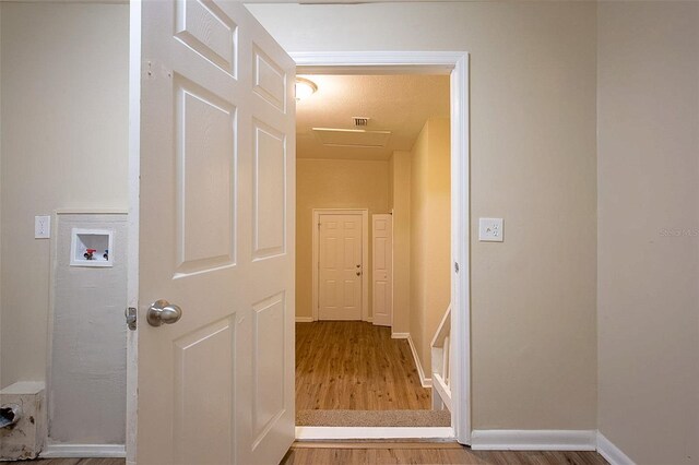 corridor with hardwood / wood-style floors