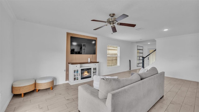 living room featuring light wood-type flooring, ceiling fan, and crown molding