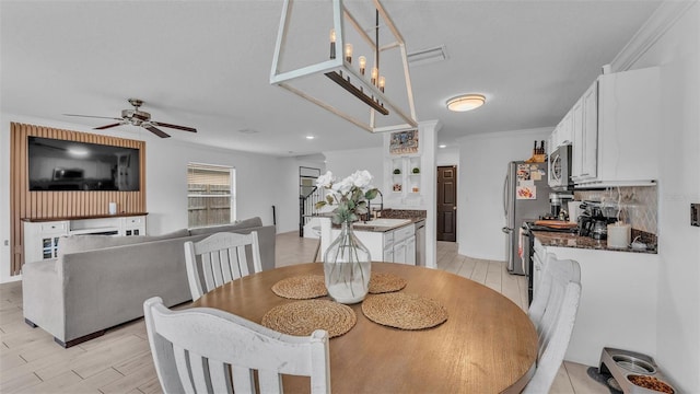 dining area with ceiling fan, light hardwood / wood-style flooring, and ornamental molding