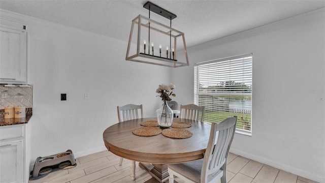 dining area with a textured ceiling, crown molding, and a notable chandelier