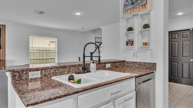 kitchen featuring dark stone counters, white cabinets, sink, stainless steel dishwasher, and ornamental molding