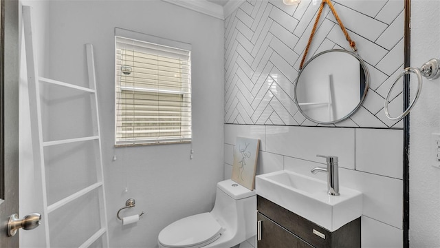 bathroom with vanity, toilet, and ornamental molding