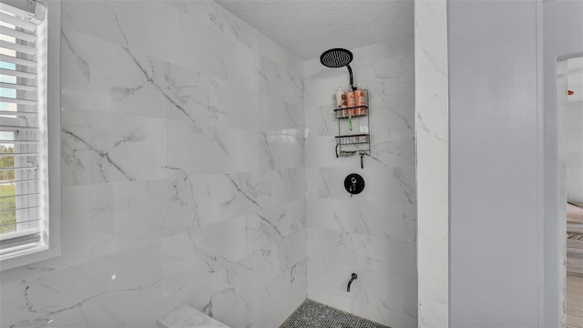 interior details featuring a tile shower and a textured ceiling