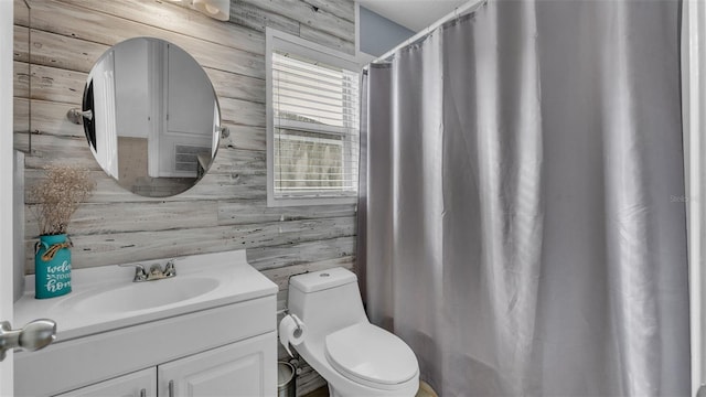 bathroom with wooden walls, vanity, and toilet